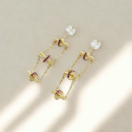 Aretes Largos Bañados en Oro con Cadenas y Detalles en Circones Fucsia