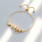 Pulsera Ajustable Bañada en Oro con Dijes de Huellita, Gato y Corazón con Brillos