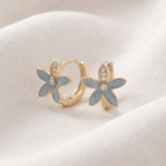 Argollas Huggies Bañadas en Oro con Diseño de Flor Esmaltada en Celeste y Detalles de Circones