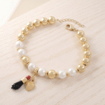 Pulsera de Esferas Bañadas en Oro y Perlas con Dijes de Protección y Corazón